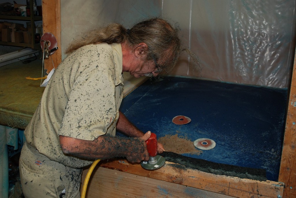 Shaping seat foam on the workbench with a sanding disc