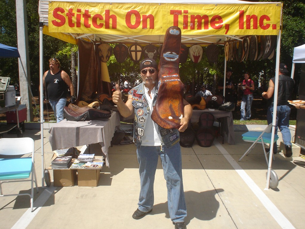 The Stitch On Time, Inc. tent at a bike show, with seats on display